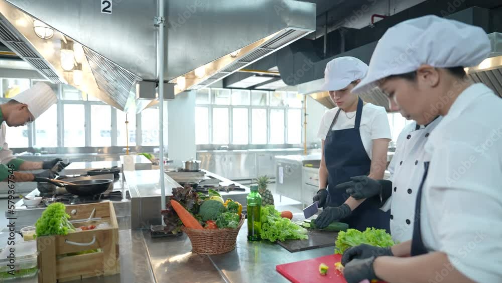Diverse group of chefs and chef assistants cooking together in the kitchen. Diverse group of chefs and chef assistants cooking together in the kitchen.