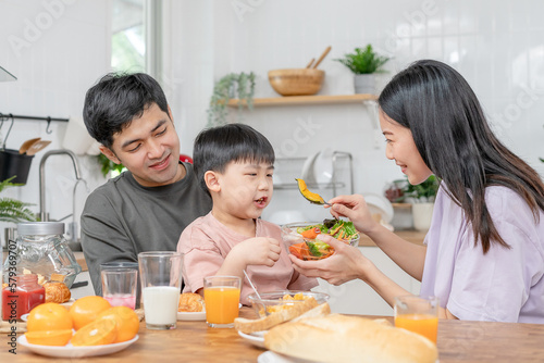 activities together during the holidays. Parents and children are having a meal together during the holidays. Mather prepare milk for son on morning, enjoy, weekend, vacant, family time, happy.
