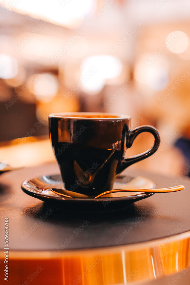 Black cup of hot coffee with golden spoon on the table. Black cup of hot coffee with golden spoon on the table.