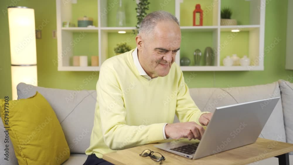 Elderly man is working on laptop at home, peaceful and carefree.
Retired old man using laptop at home, paying bills online, shopping online, doing research.

