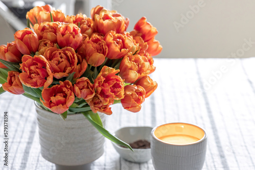 Spring composition with a bouquet of orange tulips in the interior of the house. #579378394