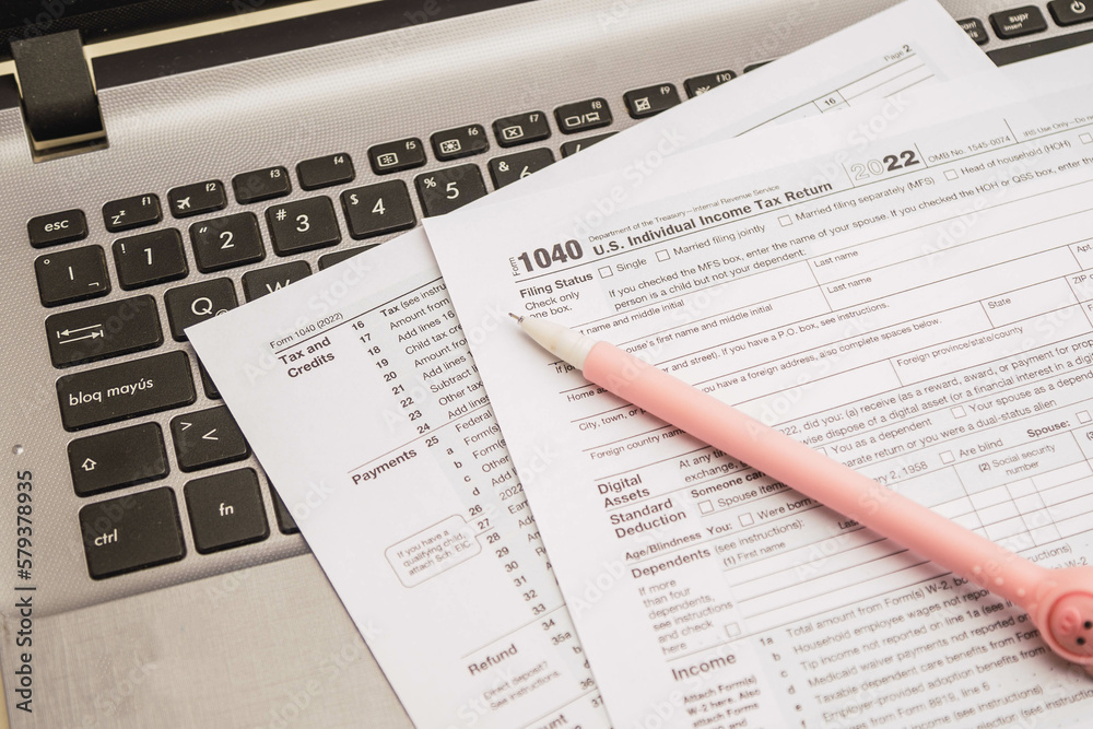 IRS 1040 tax forms , United States tax form, a laptop on a desk. US individual income tax return. Accountant working with US tax forms IRS 1040 tax forms , United States tax form, a laptop on a desk. US individual income tax return. Accountant working with US tax forms
