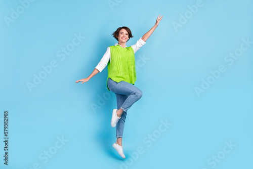 Full length photo of adorable lovely woman with bob hairstyle wear green waistcoat jumping flying isolated on blue color background