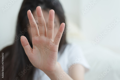 woman making frightened gesture with her palms as if trying to defend herself from someone