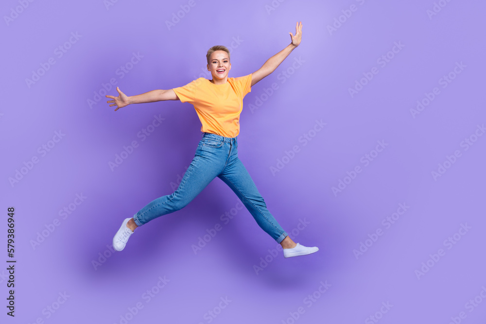 Full body portrait of overjoyed sportive lady jumping raise hands good mood isolated on purple color background