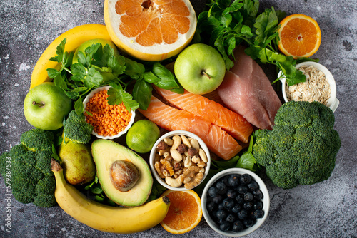 healthy foods, superfoods, meat, fish and greens on a gray background.