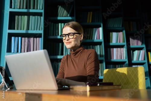 Fényképezés A perfectionist is a female employee of a design company working using a laptop on a desktop in a new office