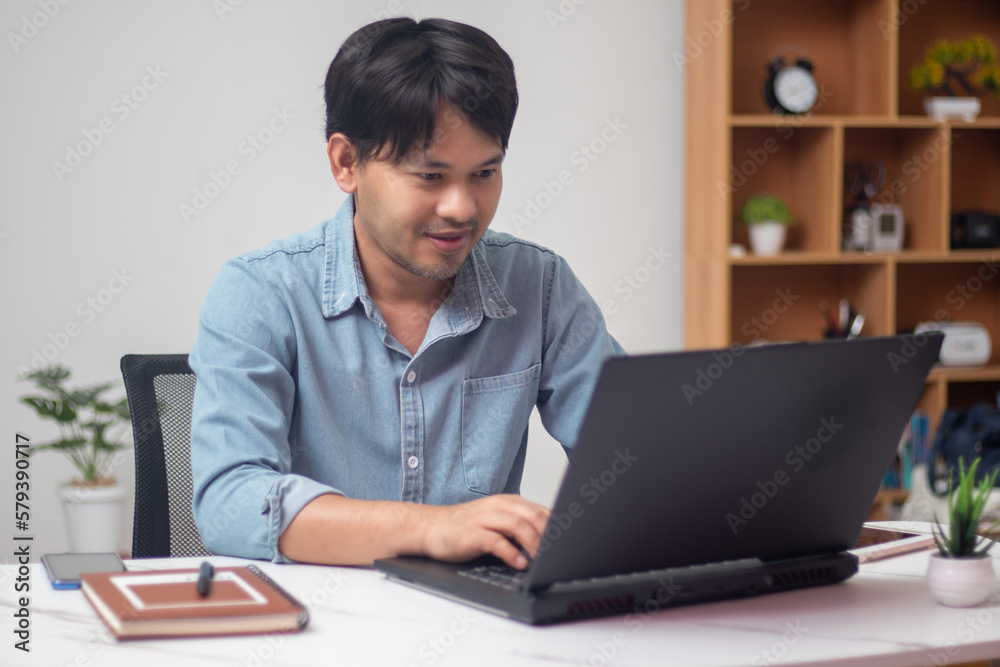 Man in denim jacket sitting and working in front of laptop Man in denim jacket sitting and working in front of laptop