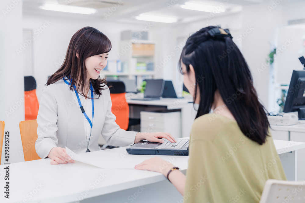 窓口で対応をする女性 窓口で対応をする女性
