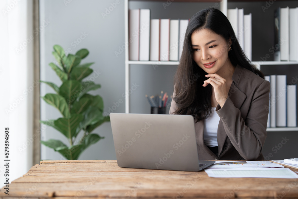 Young Asian businesswoman working with laptop computer while sitting in the office room. Young Asian businesswoman working with laptop computer while sitting in the office room.