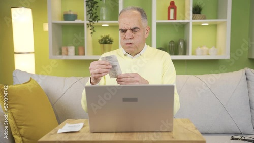 Frustrated old man, high household fuel bills.
Retired old man at home getting angry, looking at high priced exorbitant bills.
