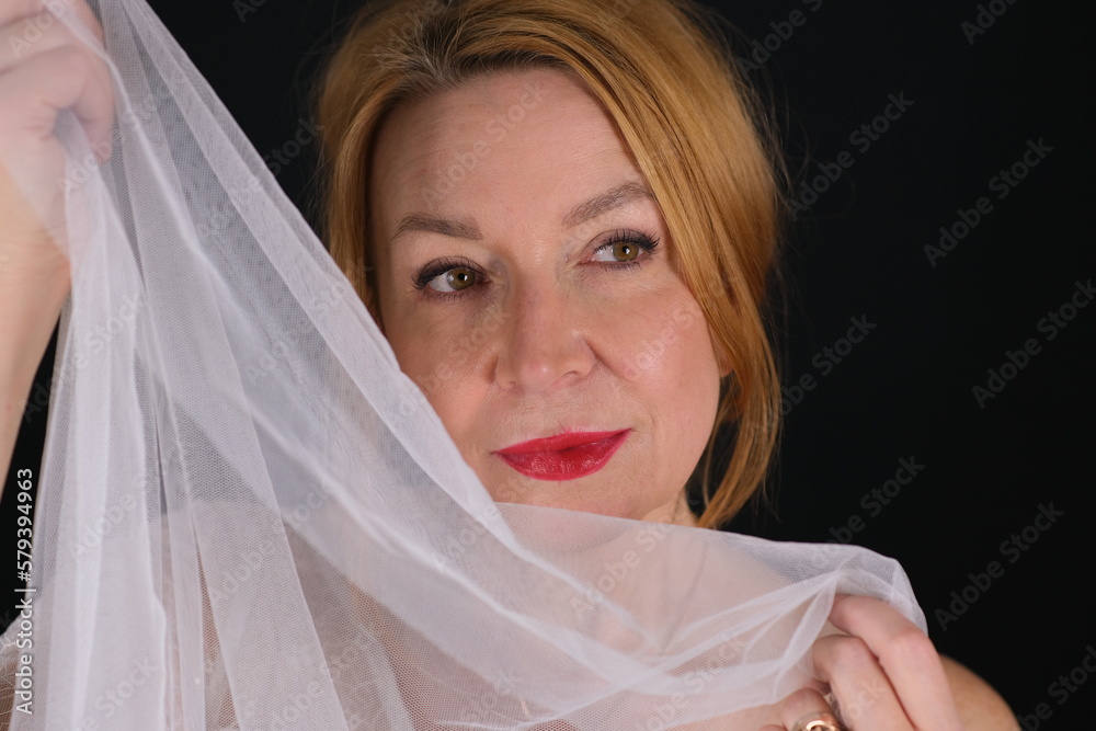 Portrait of a woman. Dark background. White cloth in hands. Portrait of a woman. Dark background. White cloth in hands.
