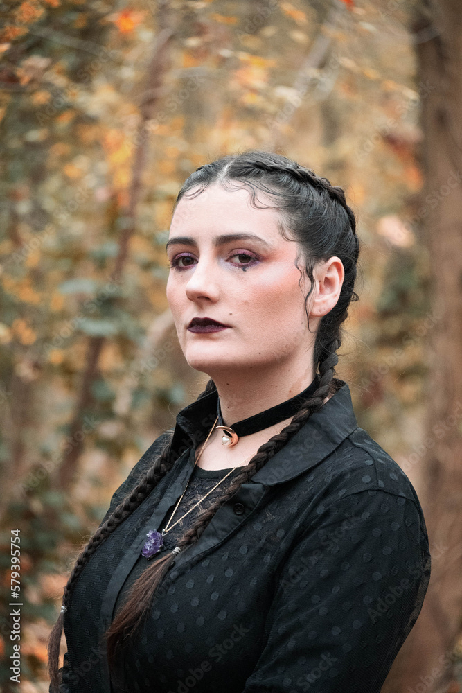 Portrait of a girl with witchy make-up in autumn forest