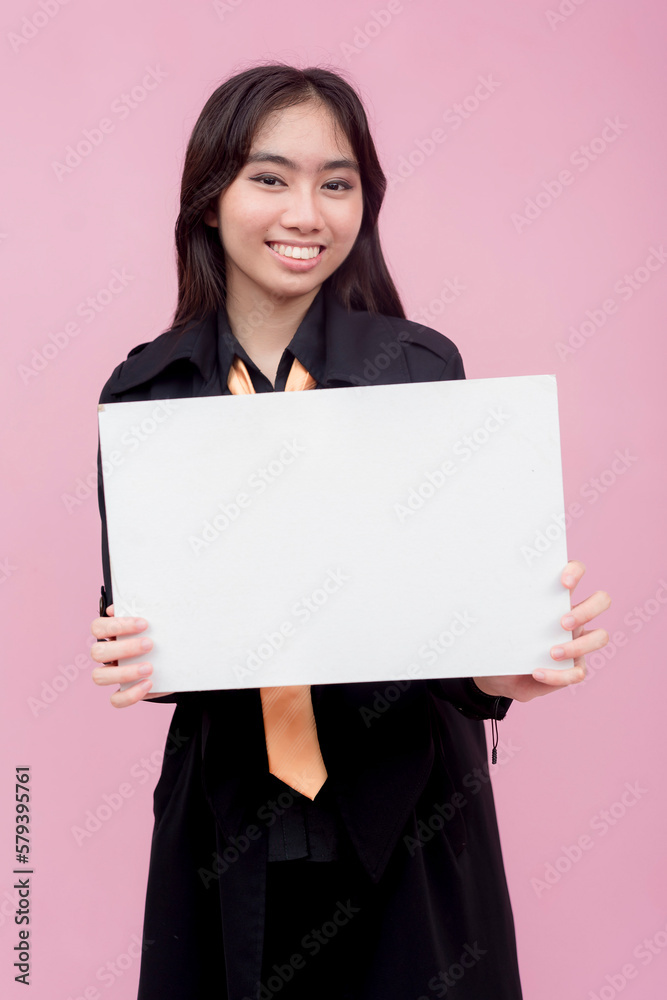 A young and pretty southeast asian lady with wavy hair holding a blank white cardboard sign. For a notice, guideline or advertisement. Isolated on a pink background. A young and pretty southeast asian lady with wavy hair holding a blank white cardboard sign. For a notice, guideline or advertisement. Isolated on a pink background.