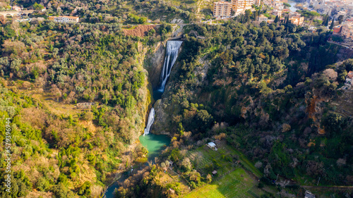 Aerial view of the Great Waterfall of Tivoli, near Rome, Italy. It is located in the park of Villa Gregoriana. Waterfall surrounded with natural cliffs and green trees. 