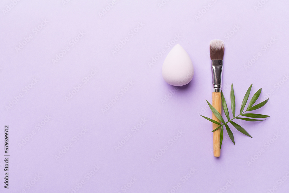 Make up brush and sponge on color background, top view Make up brush and sponge on color background, top view