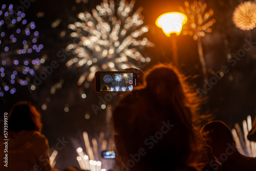 woman taking the photo of fireworks by smartphone