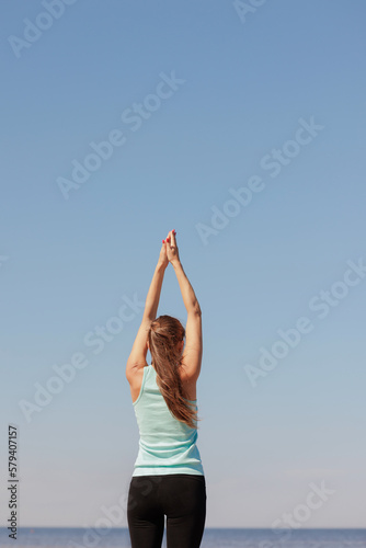 yoga, Tree Pose sporty woman does warm-up on seashore in morning. fitness millennial female trains, asana breathing practice, healthy lifestyle, love for your body, mental and physical condition