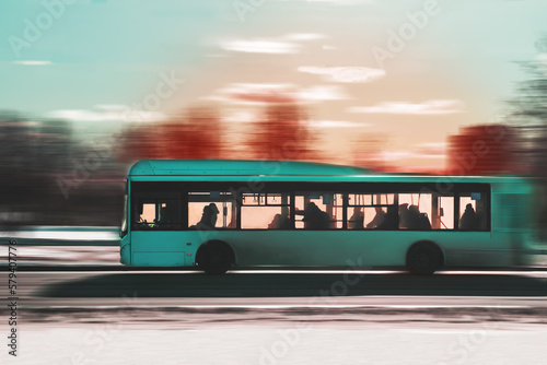 City passenger bus with silhouettes of passengers in the sunset light