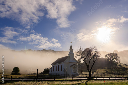 Historic small town church in West Marin County in fog and morning sun photo