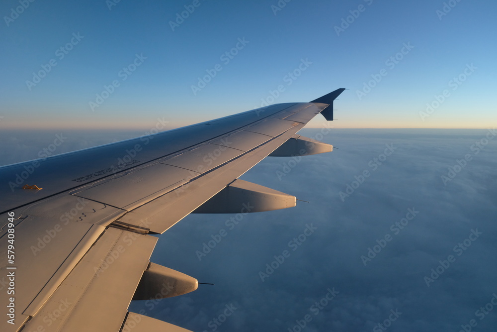 Beautiful shot of a plane wing over a layer of blue clouds Beautiful shot of a plane wing over a layer of blue clouds