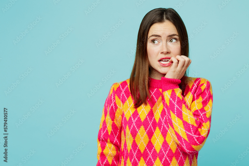 Young worried mistaken sad caucasian woman wears bright casual clothes look aside on area biting nails fingers isolated on plain pastel light blue cyan background studio portrait. Lifestyle concept. Young worried mistaken sad caucasian woman wears bright casual clothes look aside on area biting nails fingers isolated on plain pastel light blue cyan background studio portrait. Lifestyle concept.