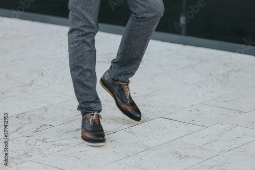 Stylish man in textured gray suit pants and dark brogue shoes