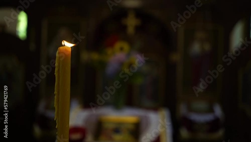 Closeup shot of a lighting candle in a church on a blurred background photo