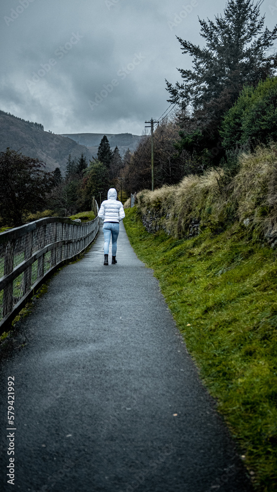Woman walking on stone path during misty weather in the mountains