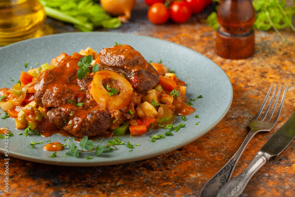 Ossobuco served with stewed vegetables.