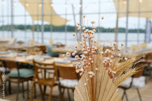 Fotografia Detailed view of dried flowers in an empty vintage lakeside restaurant