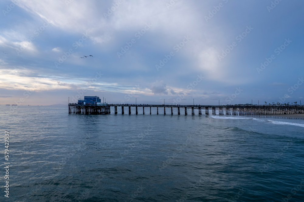 Obraz premium Drone shot of a metallic pier of the sea under the cloudy sky, cool for background