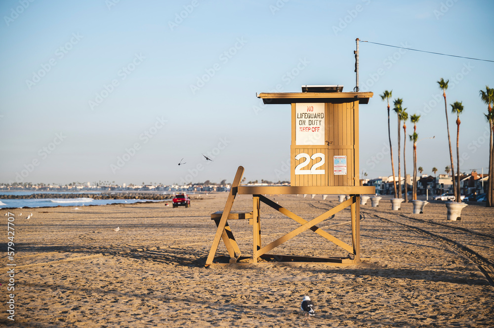 Naklejka premium Light brown wooden lifeguard stand on the sandy coast of Newport in California, USA
