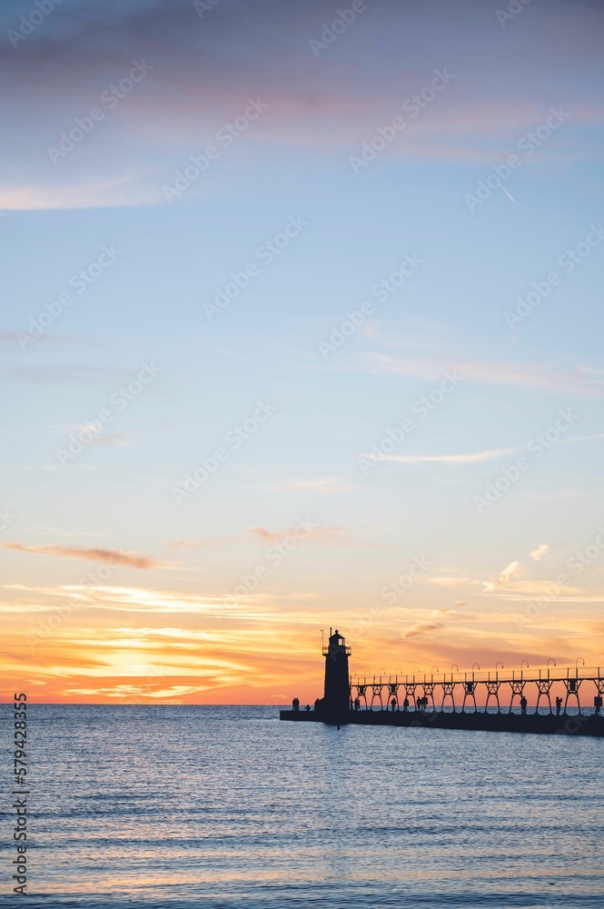 Vertical view of a lighthouse overlooking a beautiful seascape at scenic sunset