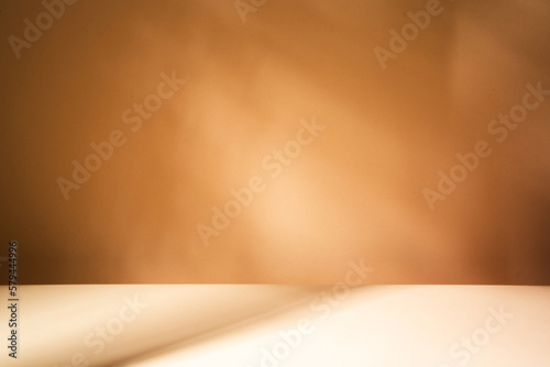 Φωτογραφία Empty table on brown background with natural shadows on the wall