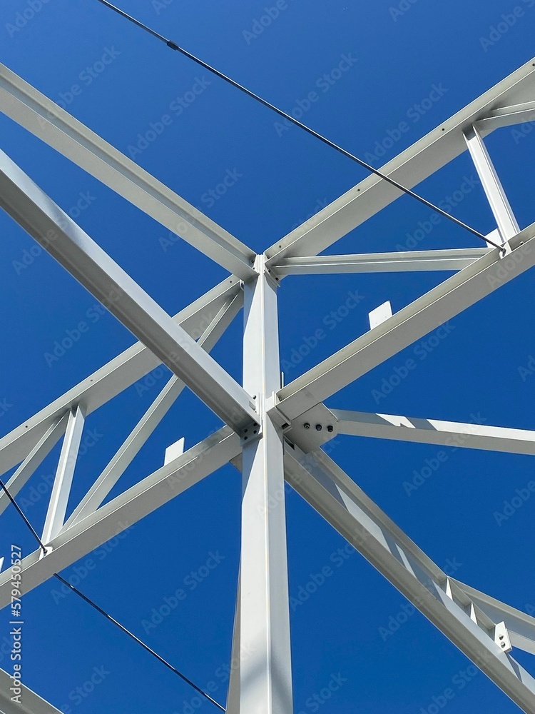Fototapeta premium Vertical shot of steel columns and beams on a construction site under a blue sky