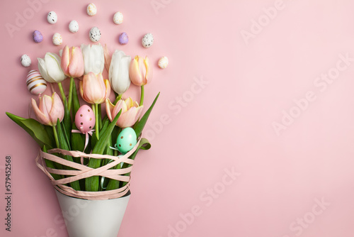 Easter composition of pink and white tulips, ribbons and decorative eggs on a pink background. Tulips bouquet, spring flowers. Content for Easter holiday. Flat lay, top view, close up, copy space