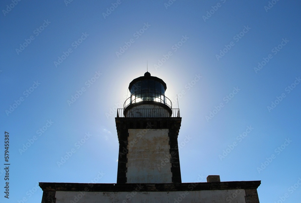 a large light house with the sun shining through the sky a large light house with the sun shining through the sky