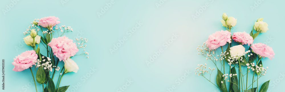 Top view image of delicate lisianthus flowers over pastel blue background