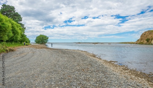 Pebbles on Hurunui River Mouth under blue cloudy sky in South Island  New Zealand