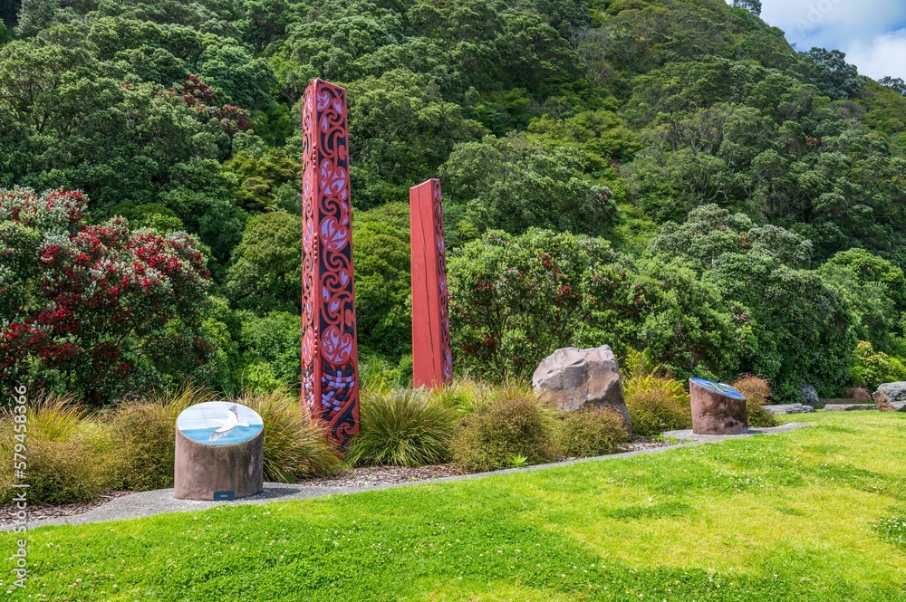 Fototapeta premium Scenic view of tribal Maori carvings in the Whakatane park surrounded by evergreen hills