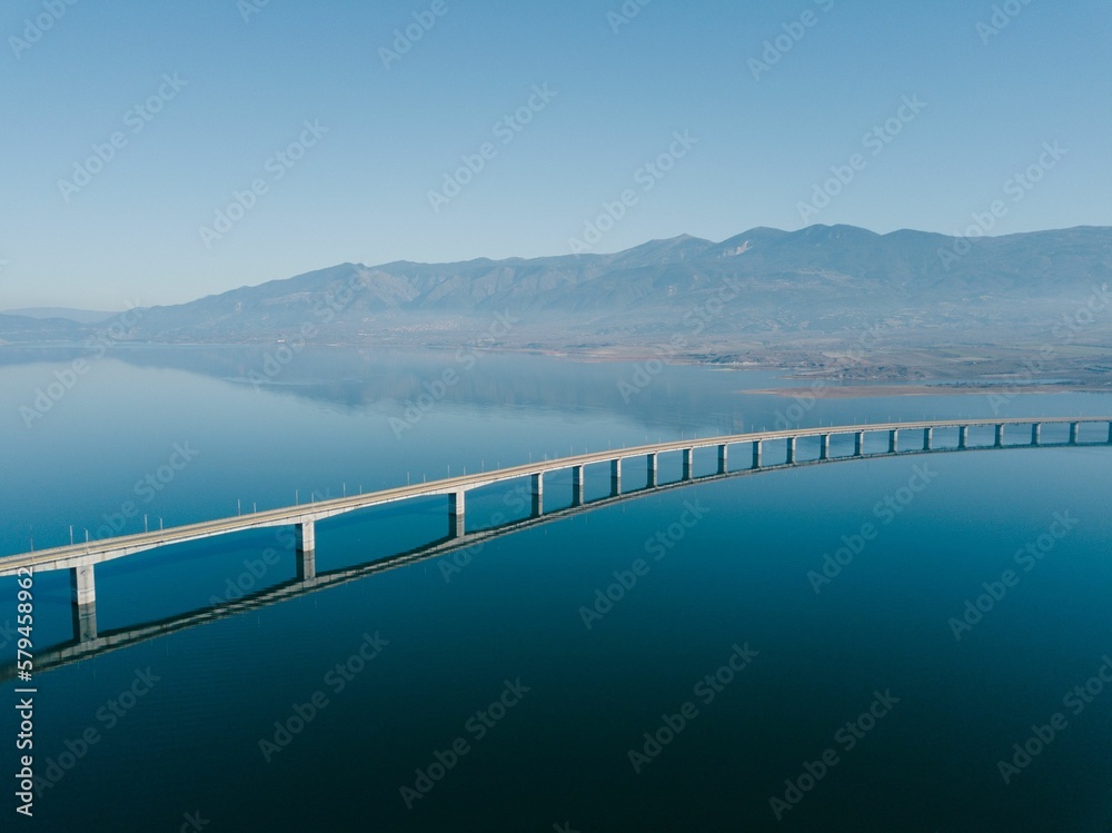 Aerial view of the Lake Polyfytos Bridge with a blue sky in the background, Greece