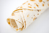 Pita or tortilla lavash rolled into tube without filling, top view, selective focus