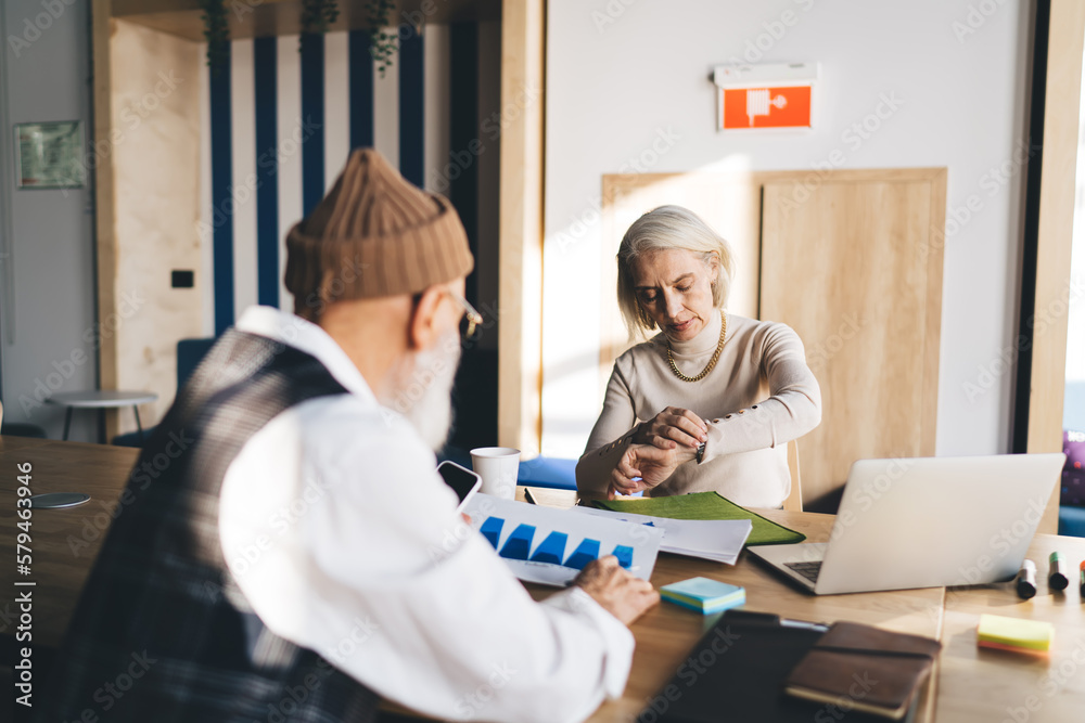 Obraz premium Senior woman sitting in office with elderly man