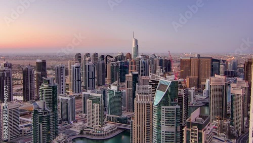 Wallpaper Mural Dubai marina harbor with boats and yacht panorama from night to day transition timelapse illumination lights turn off, UAE. Aerial view from above with many skyscrapers and towers under construction Torontodigital.ca