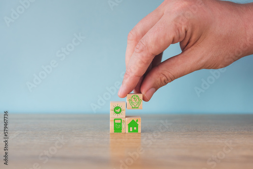 Carbon neutral concept. Net zero greenhouse gas emissions target. Climate neutral long term strategy. Stacking wooden cubes with green net zero and save world icon on grey background.
