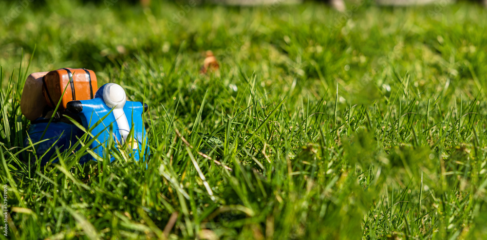 Naklejka premium Toy scooter on green grass. Banner. Place for text. Delivery, active lifestyle, travel concept.