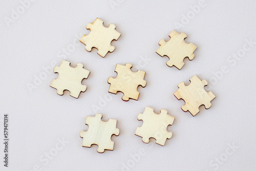 Seven wooden puzzles on beige background, copy space