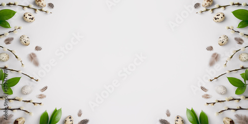 Eco Easter banner. Pussy willow branches, green leaves, natural quail eggs and feathers on light grey background. Spring holiday composition. Willow catkins and eggs. Top view, flat lay, copy space.