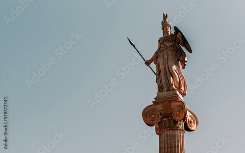 Statue of Athena, the ancient Greek goddess of wisdom and knowledge, who is represented as a powerful warrior with helmet, shield and spear. Travel to Athens, Greece.